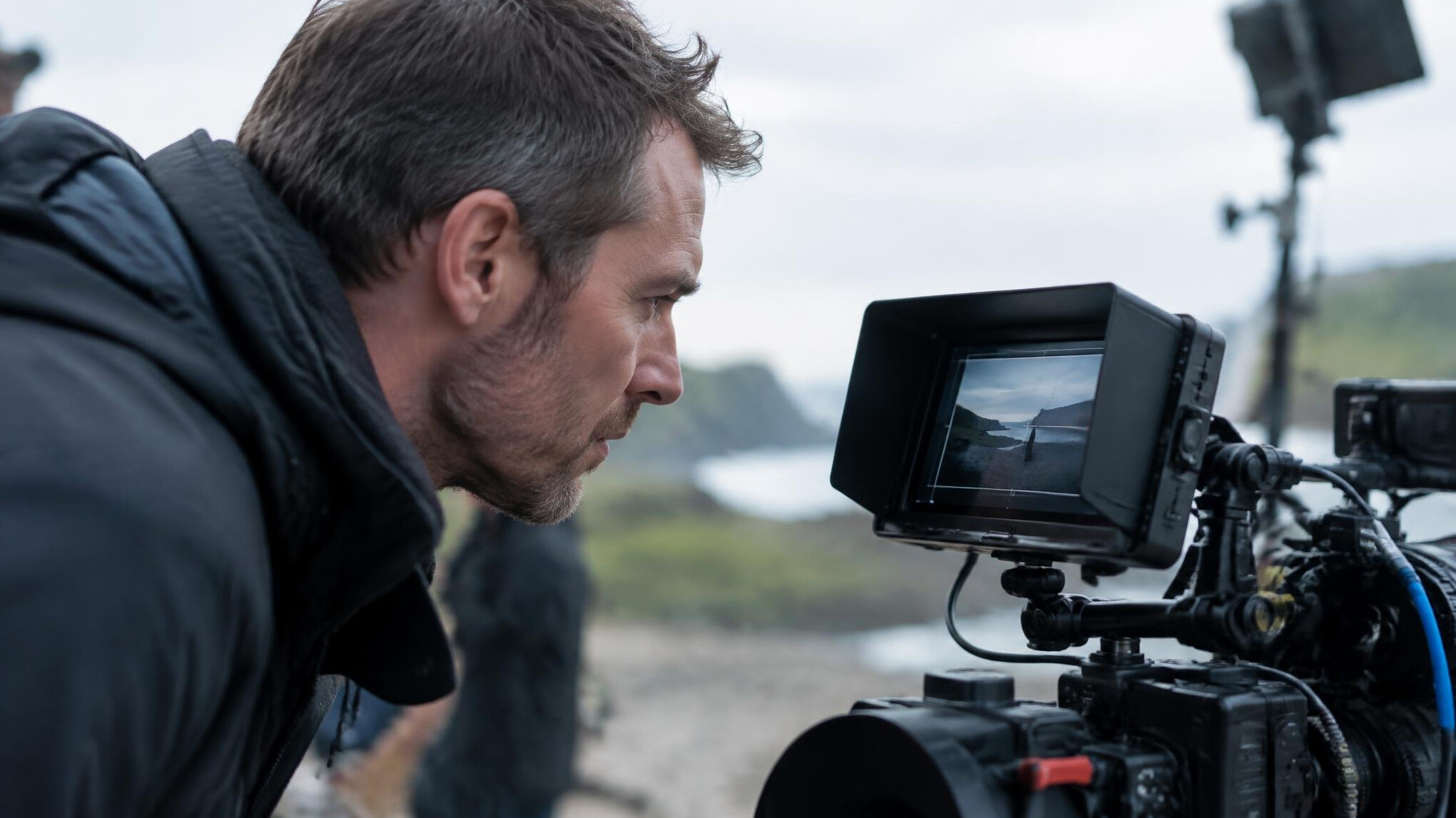 Camera operator adjusting framing through a viewfinder monitor