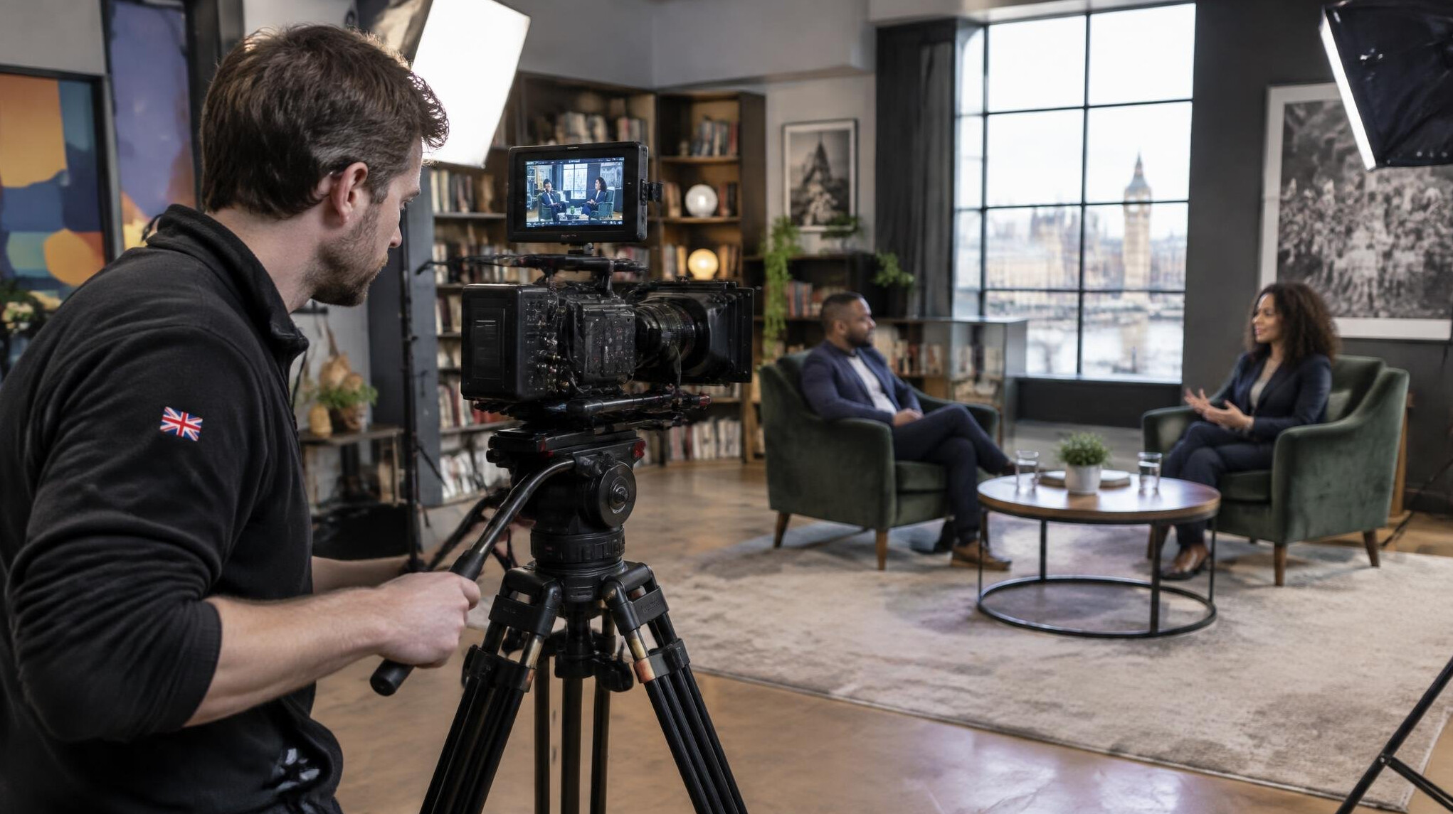 Camera operator filming an interview setup with softbox lighting